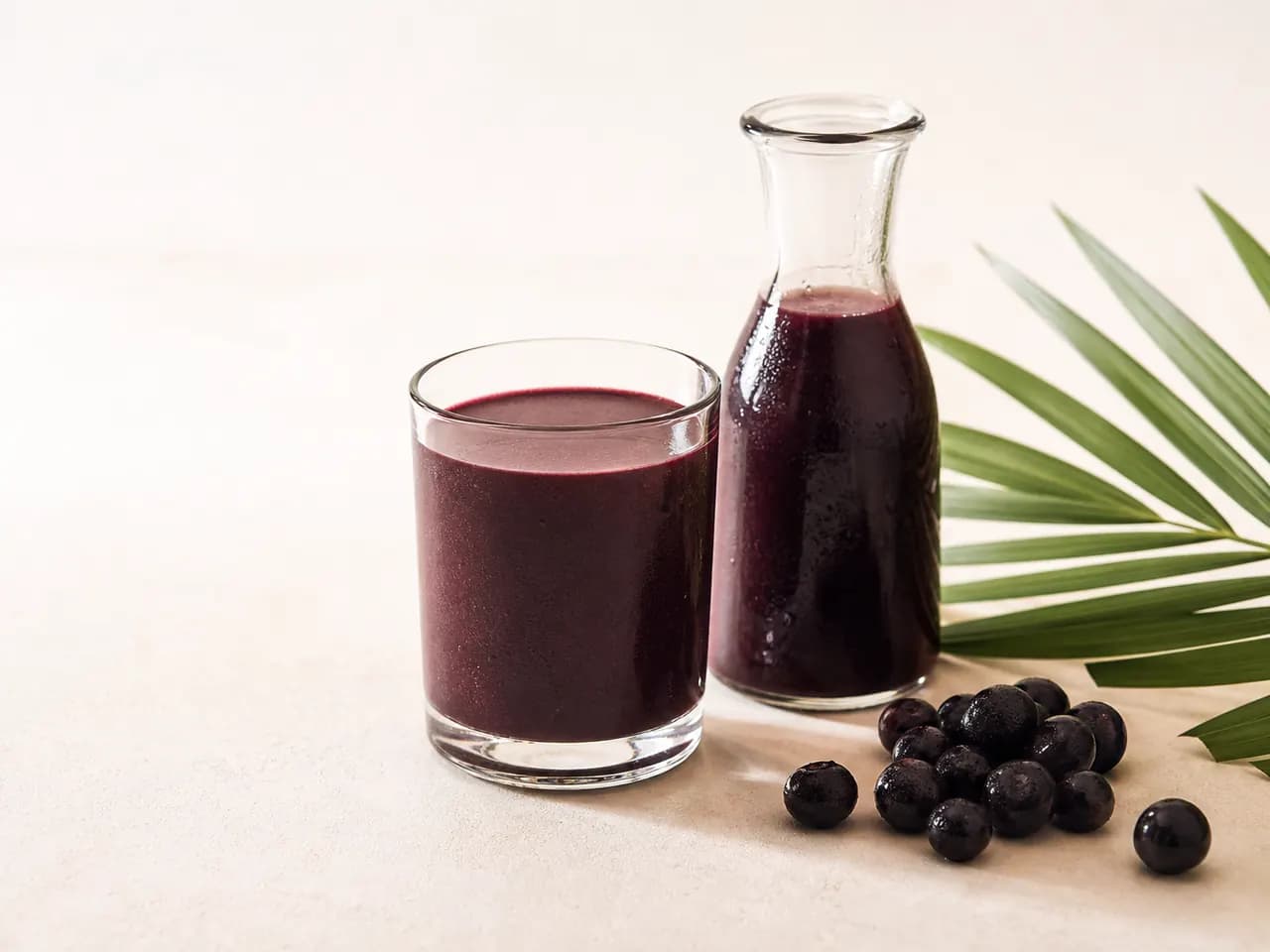 Finished deep purple açaí berry beverage in a glass and carafe
