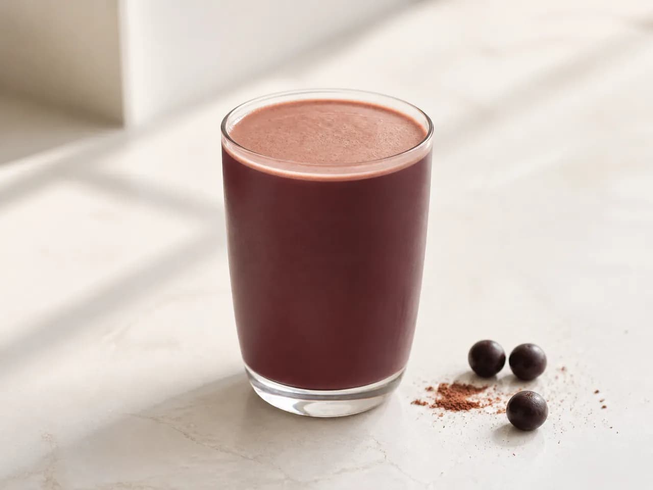 Finished cocoa and açaí beverage served in a clear glass