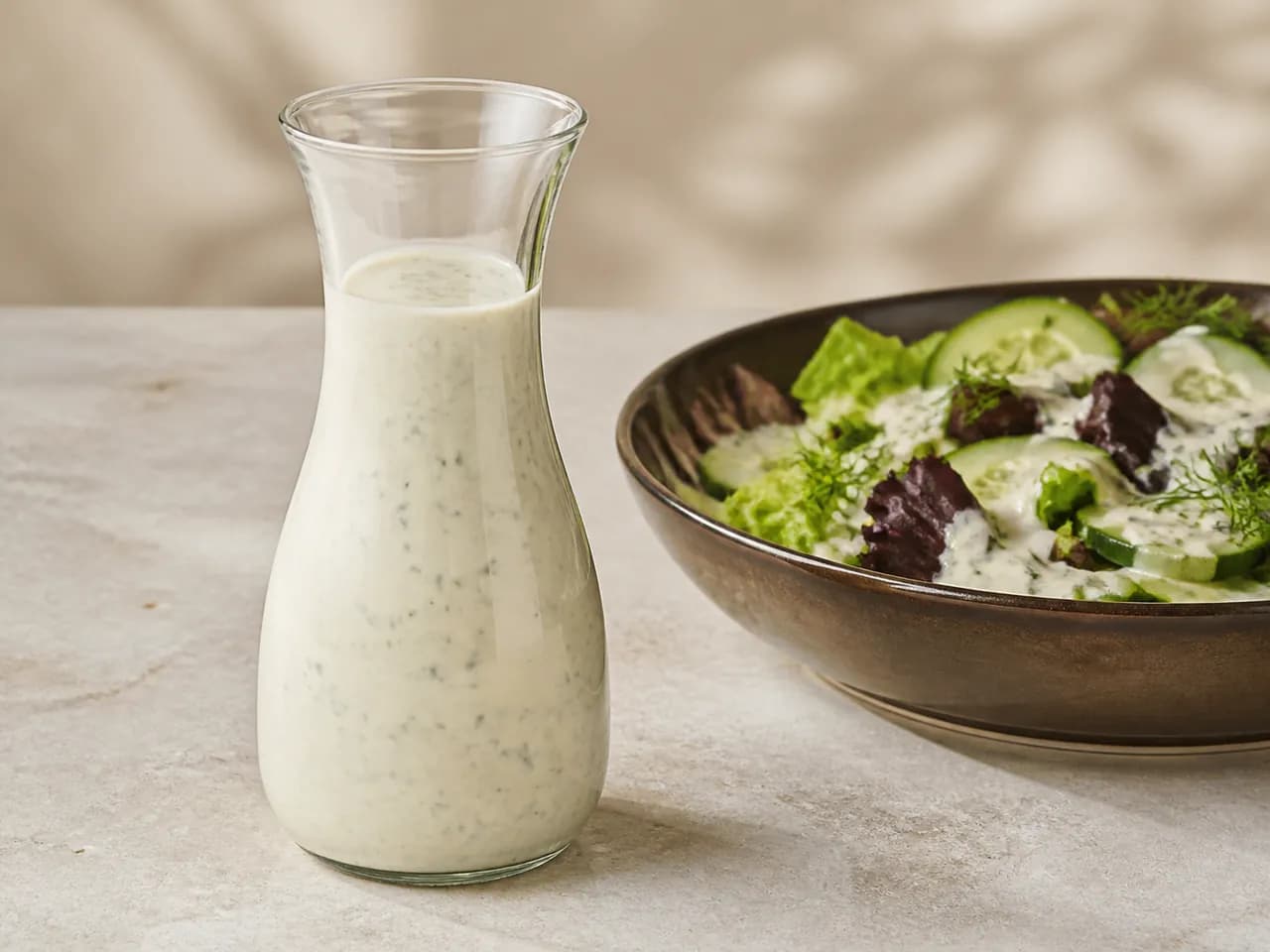 Finished pourable creamy herb dressing in a glass carafe